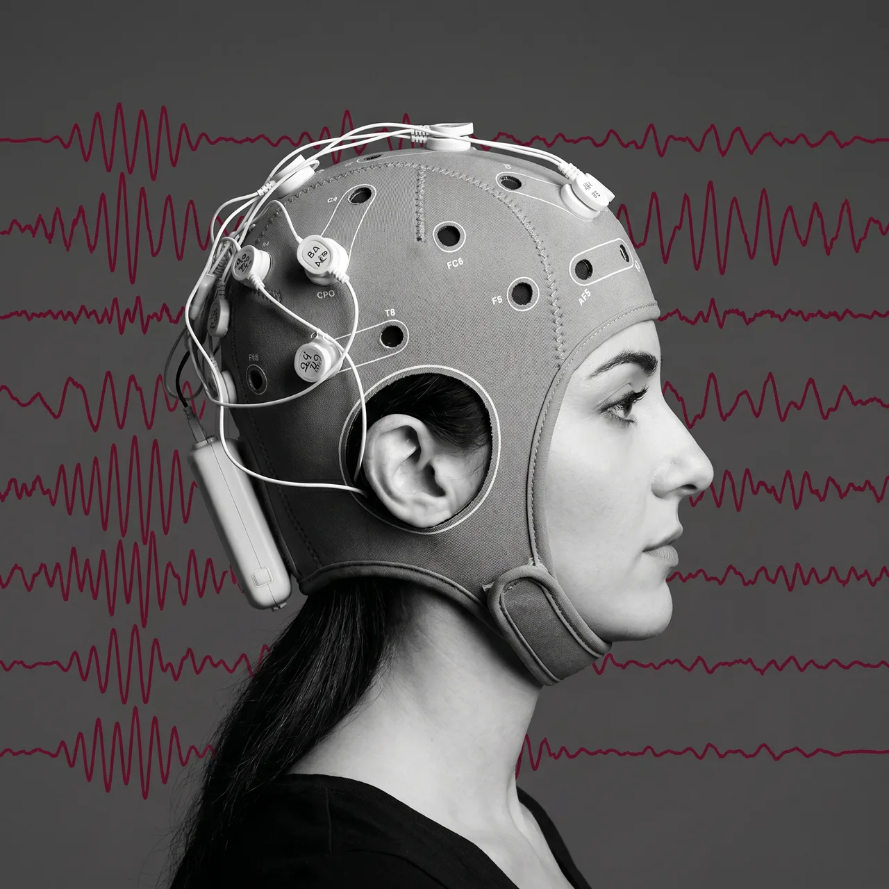 Black-and-white profile with an EEG headset and brainwaves in crimson